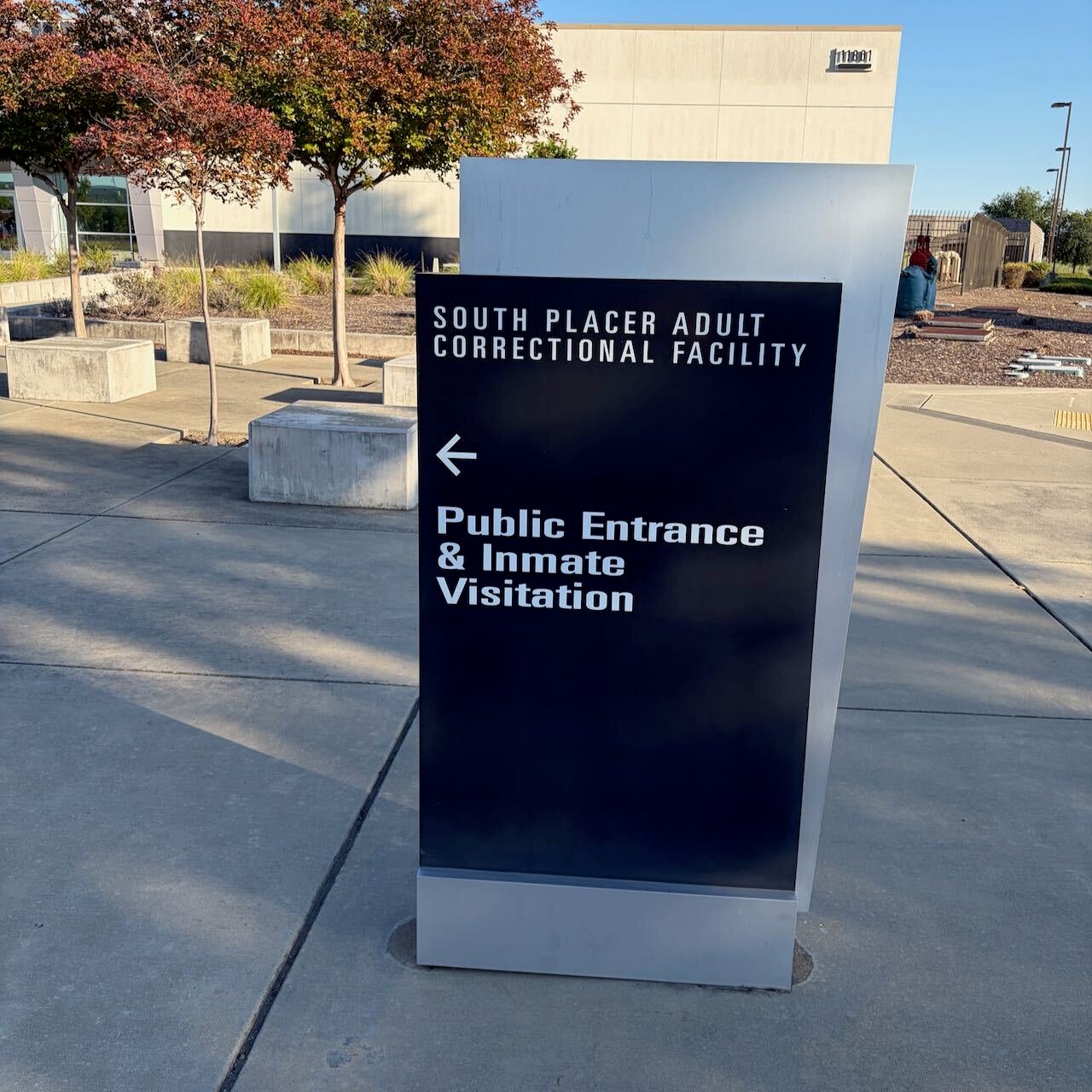 Front signage providing directions to South Placer Jail Entrance in Roseville California that reads South Placer Adult Correctional Facility Public Entrance & Inmate Visitation