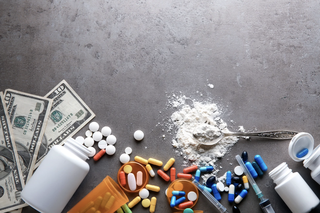 different types of drugs next to dollar bills
