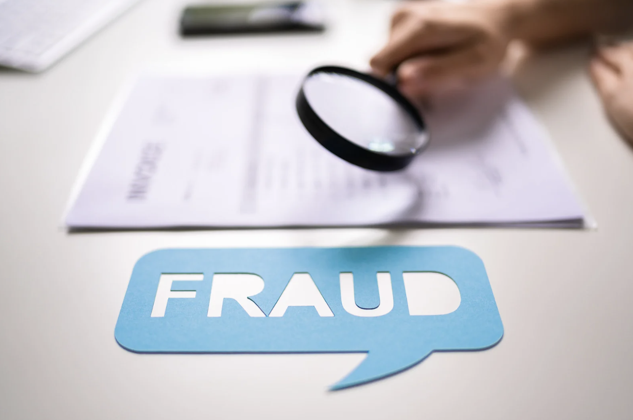 the word fraud in a speech bubble and an insurance document in the background
