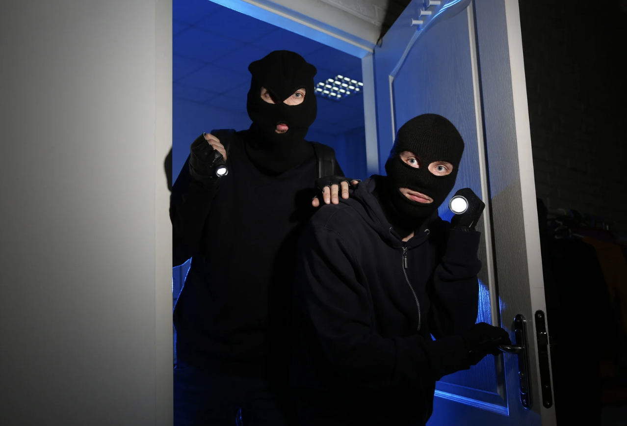two guys in ski masks breaking into a house at night 