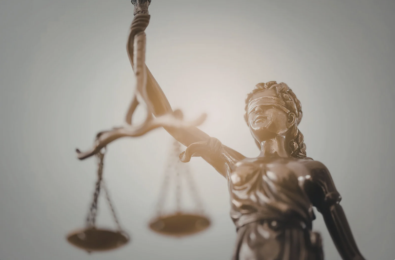 a bronze statue of lady justice holding scales upward