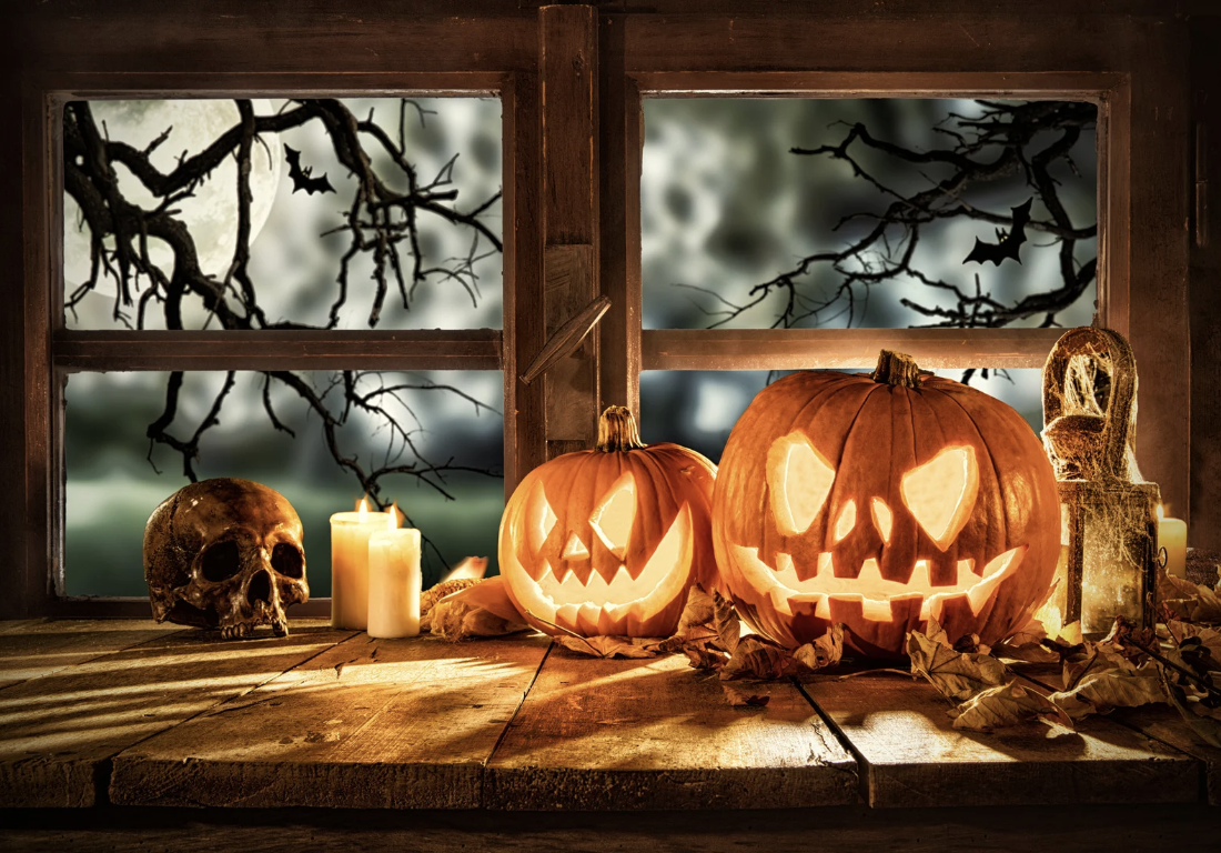 Jack'o lanterns by a window during a spooky night