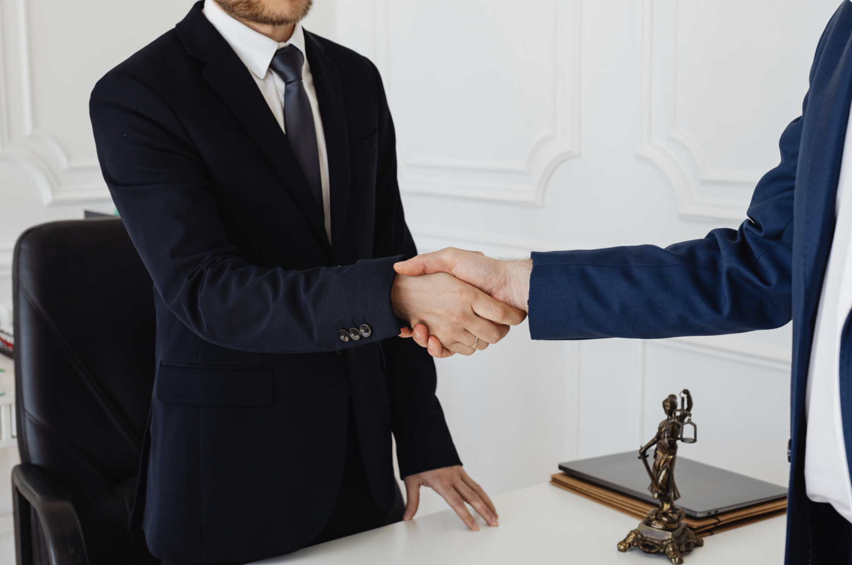 two lawyers shaking hands in an attorneys office 