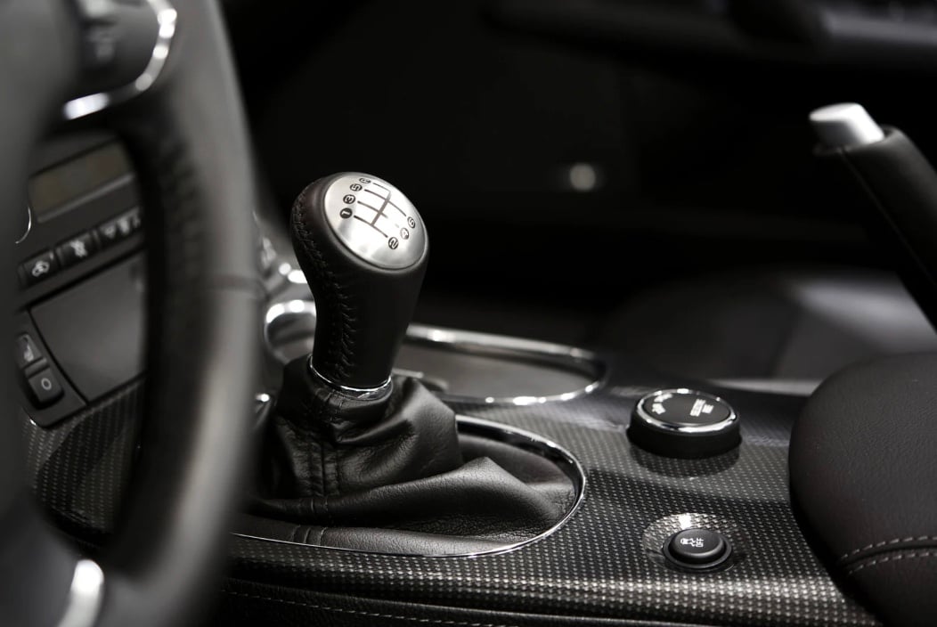 an image of the manual gear shift component of a car, along with the steering wheel and the drive-train changer
