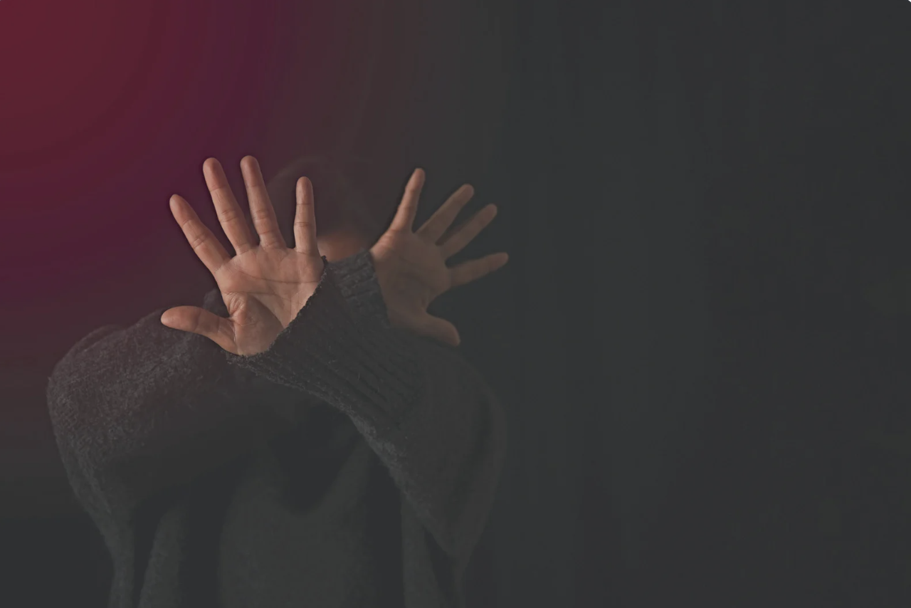 a person holding their hands up to protect themselves 