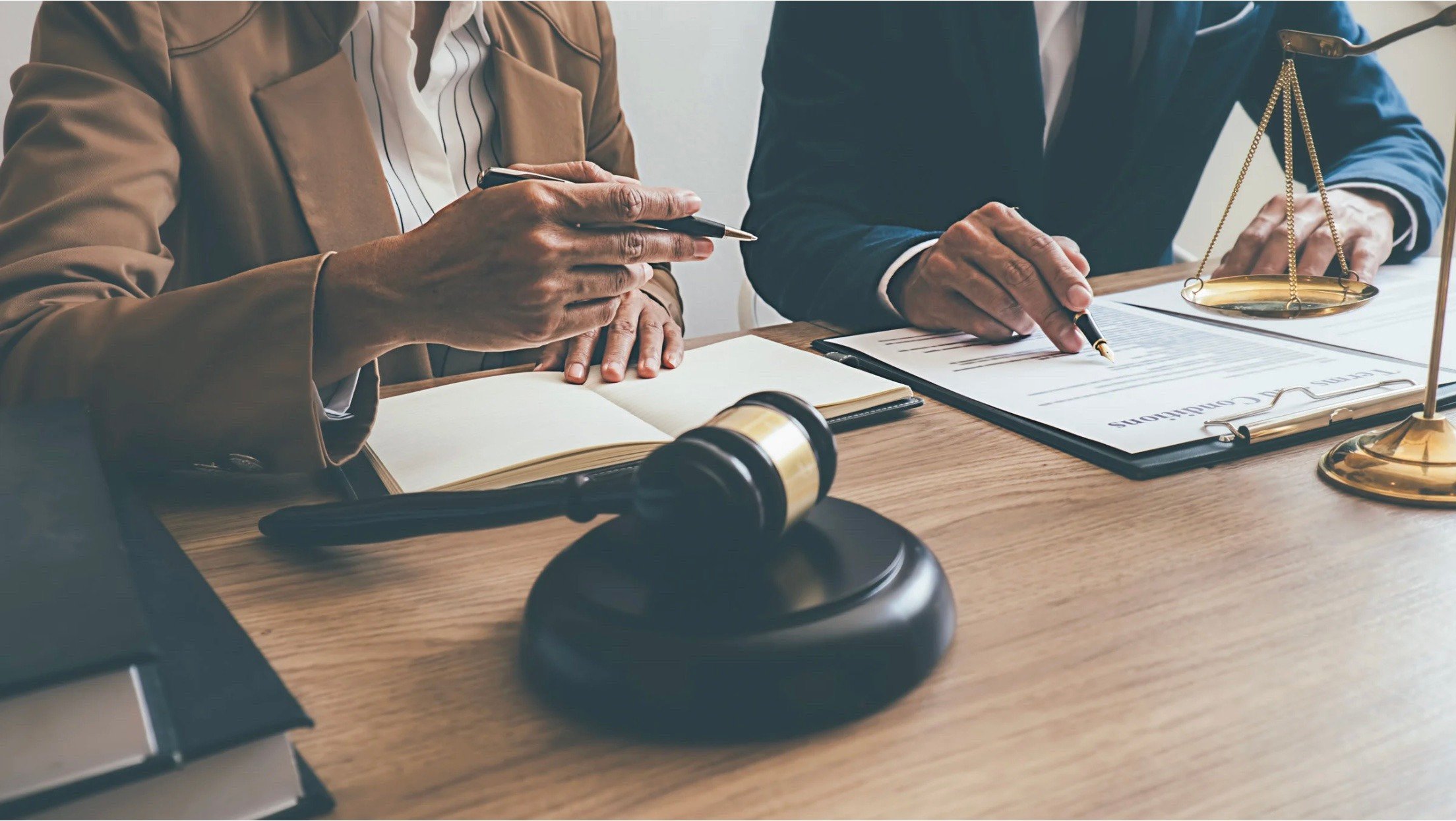 A lawyer and a bail bonds agent going over paperwork together at a desk