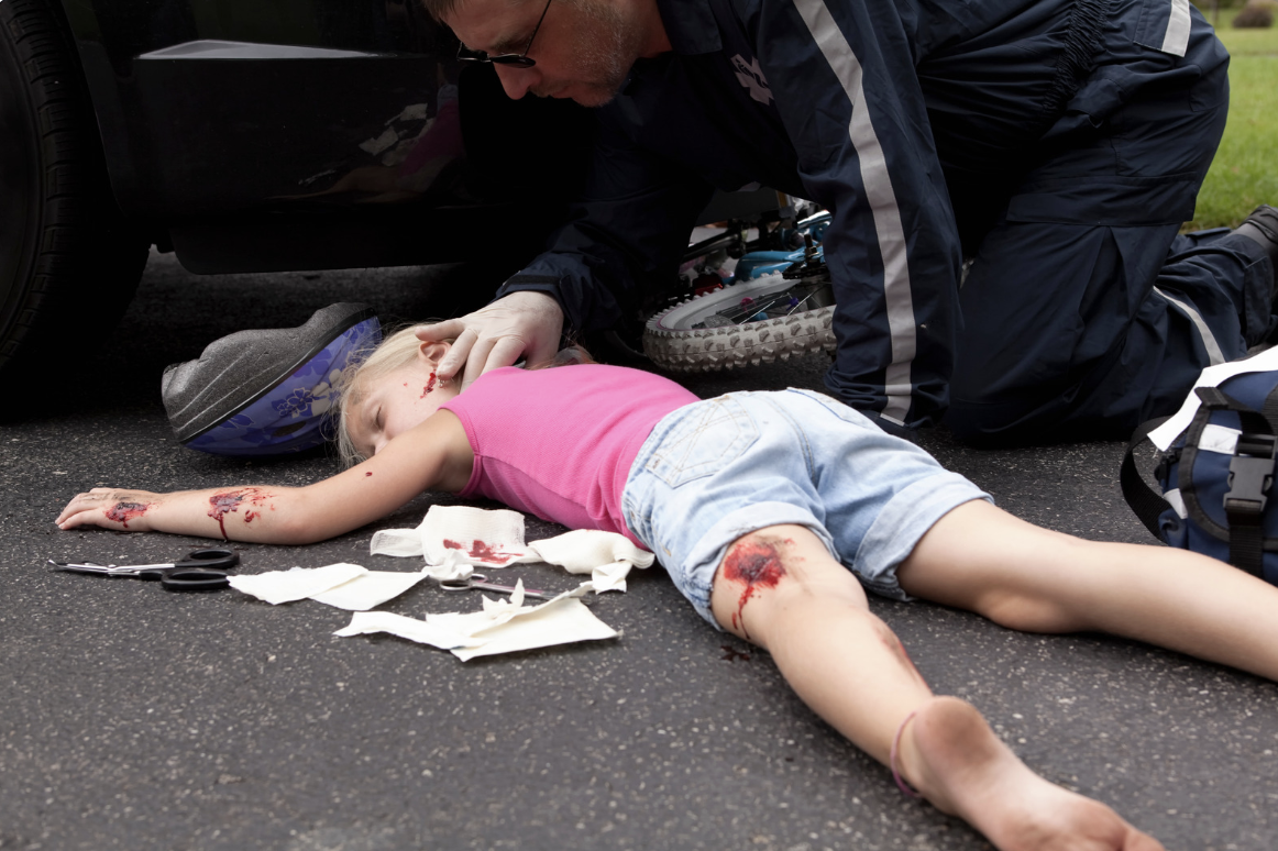 a little girl laying on her stomach in dire condition after getting hit by a car 