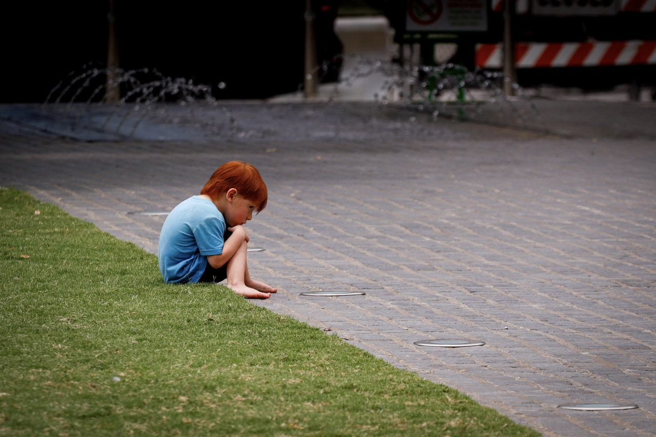 a child sitting alone on a pavement 