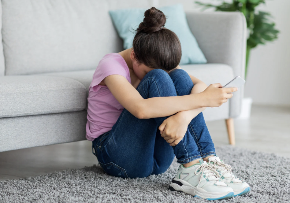 a teenager curling up in front of a couch 