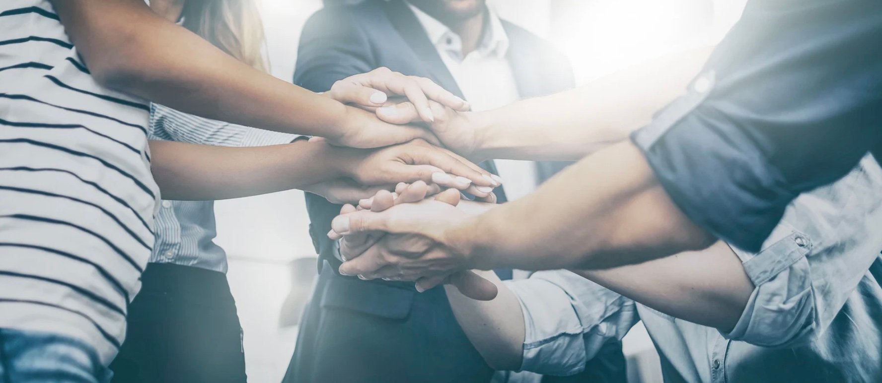 a group of hands stacked together in unity