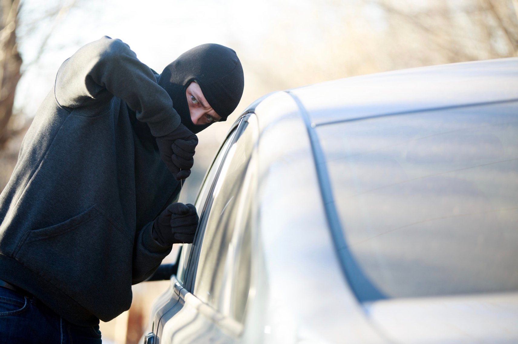 a man breaking into a car