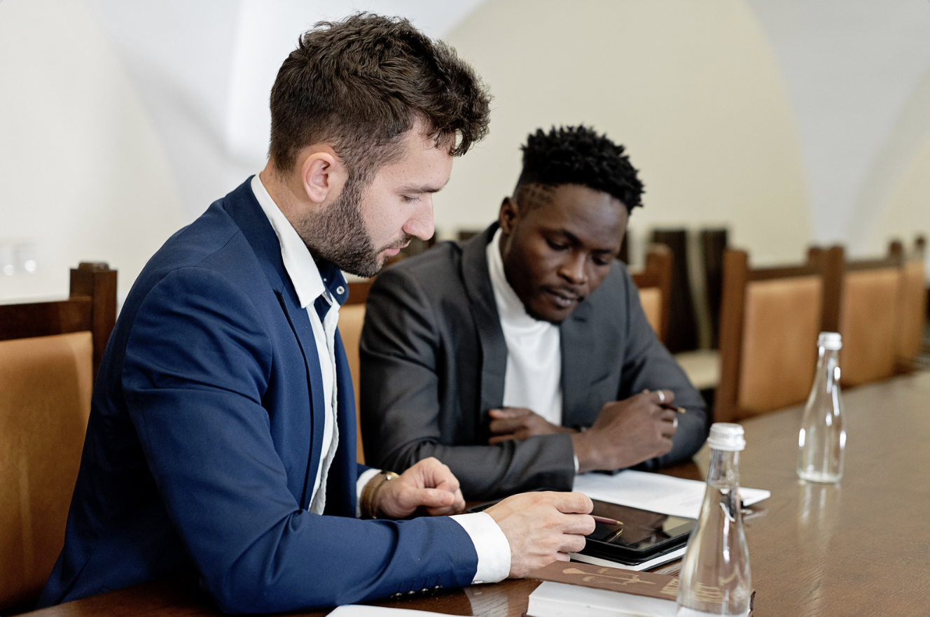 two men looking at an iPad, reviewing information 