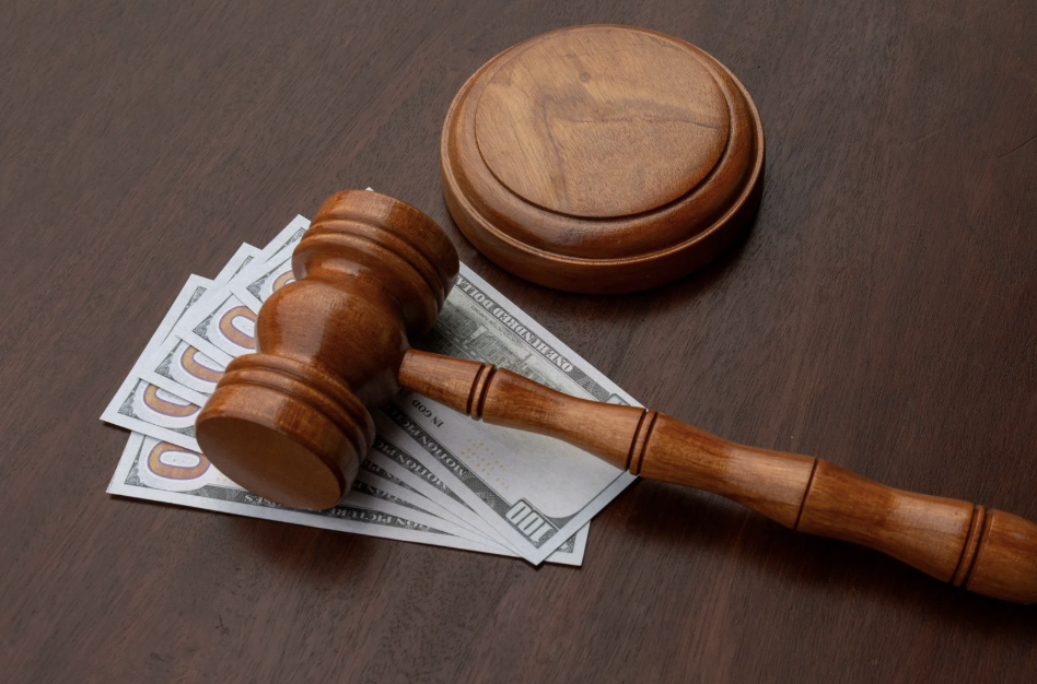 A gavel on top of five-one hundred dollar bills