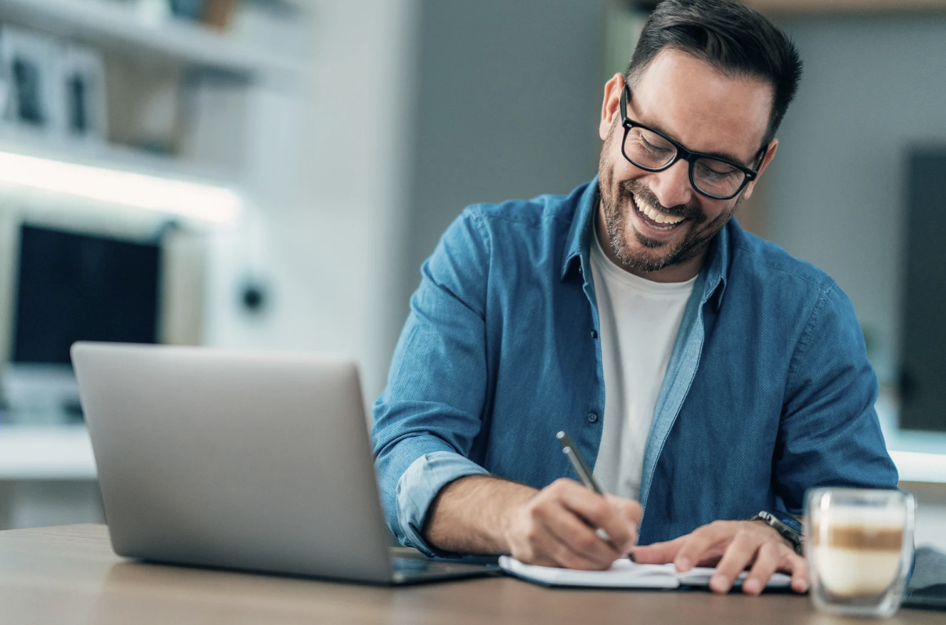 a man writing down notes from a. video call