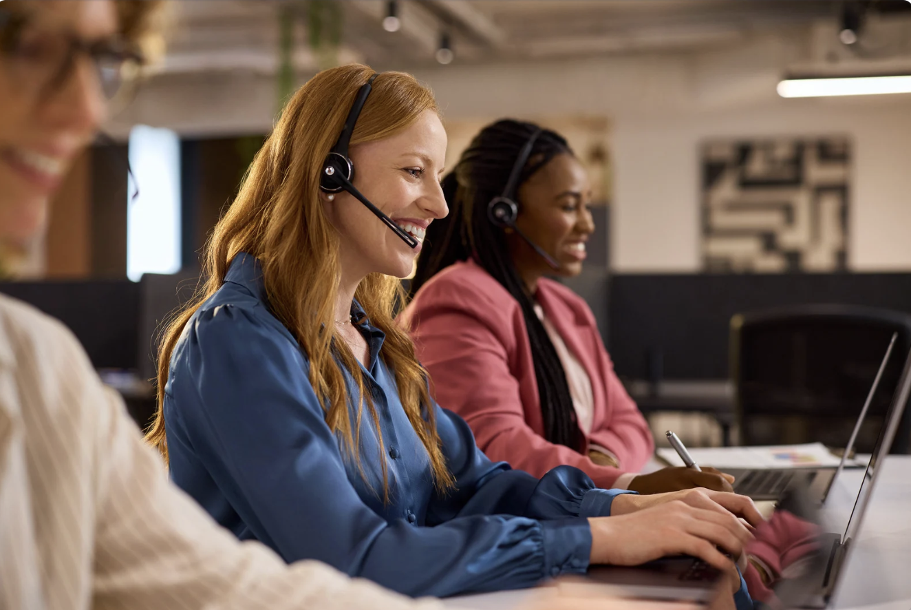 a line of agents, at their computers at their desks and on phone calls