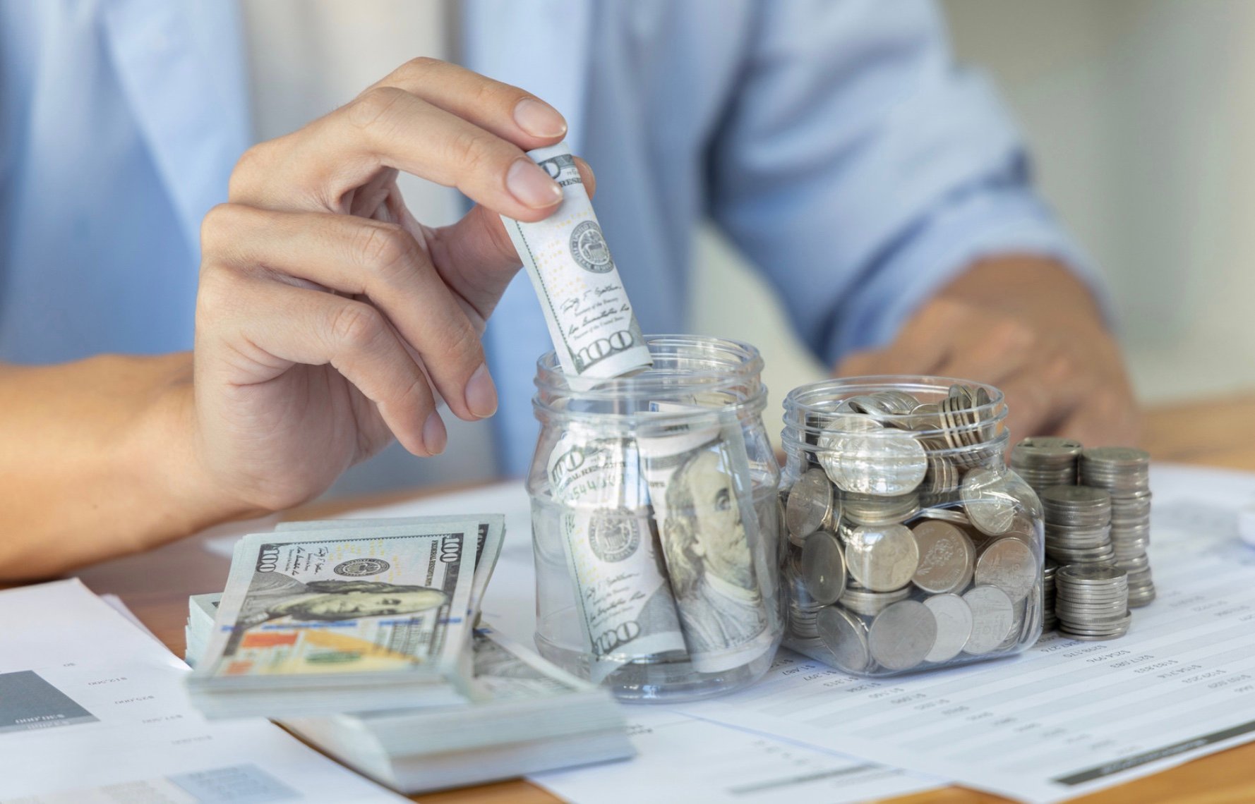 a person assembling money into jars 