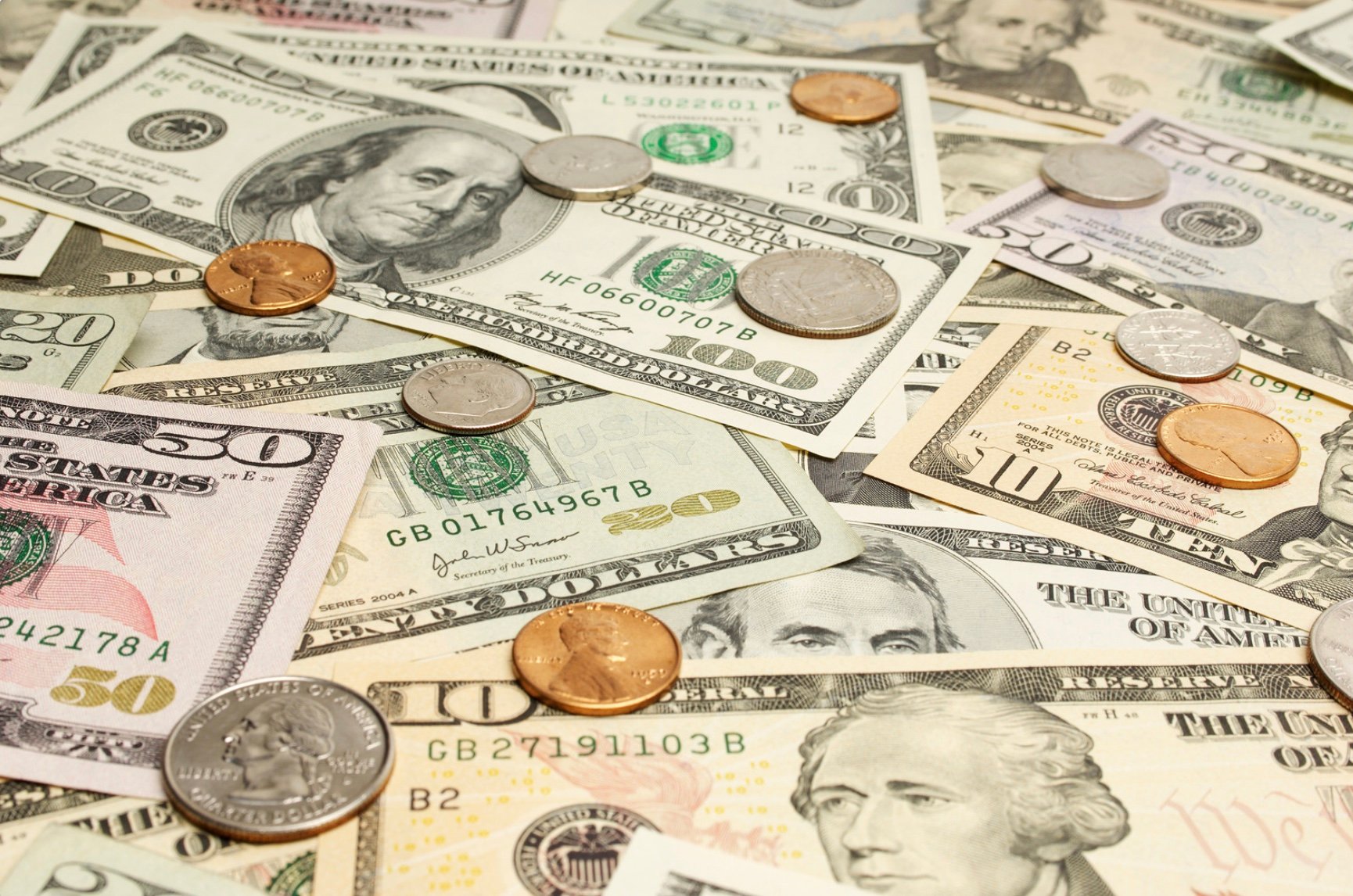 a mixed pile of dollar bills and coins