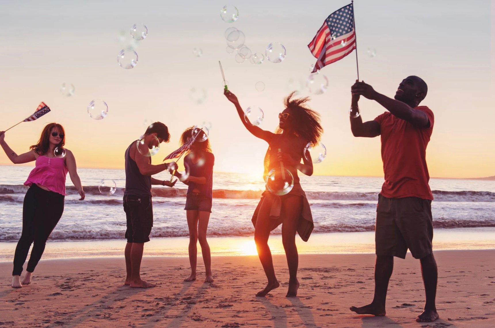a group of friends celebrating the Fourth of July on a beach