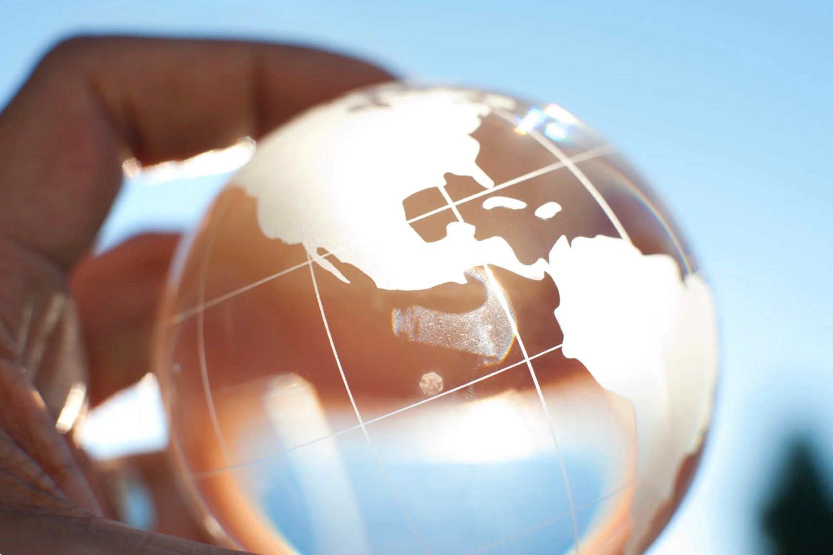 a hand holding a crystal globe