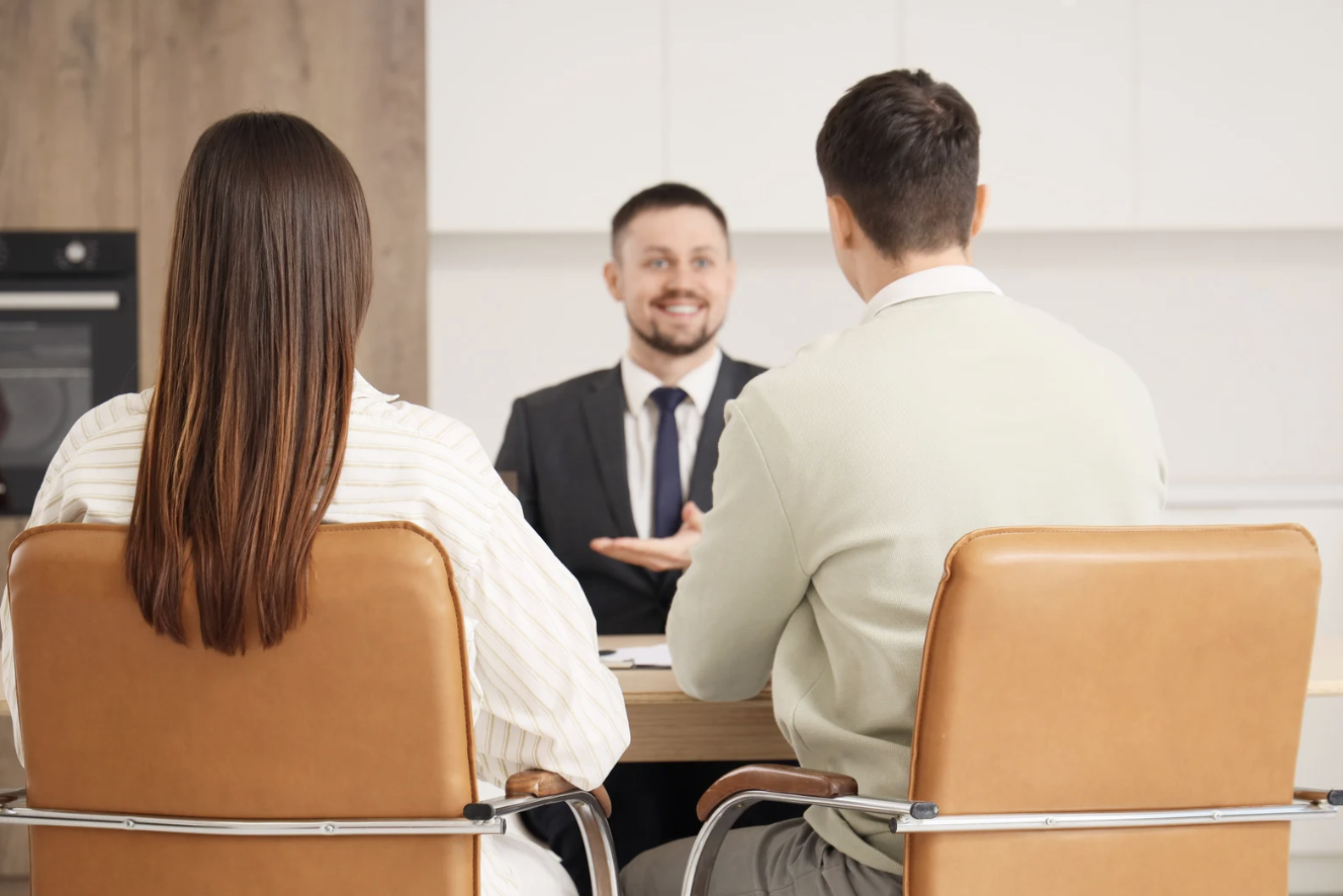 a man in a suit having a meeting with a couple
