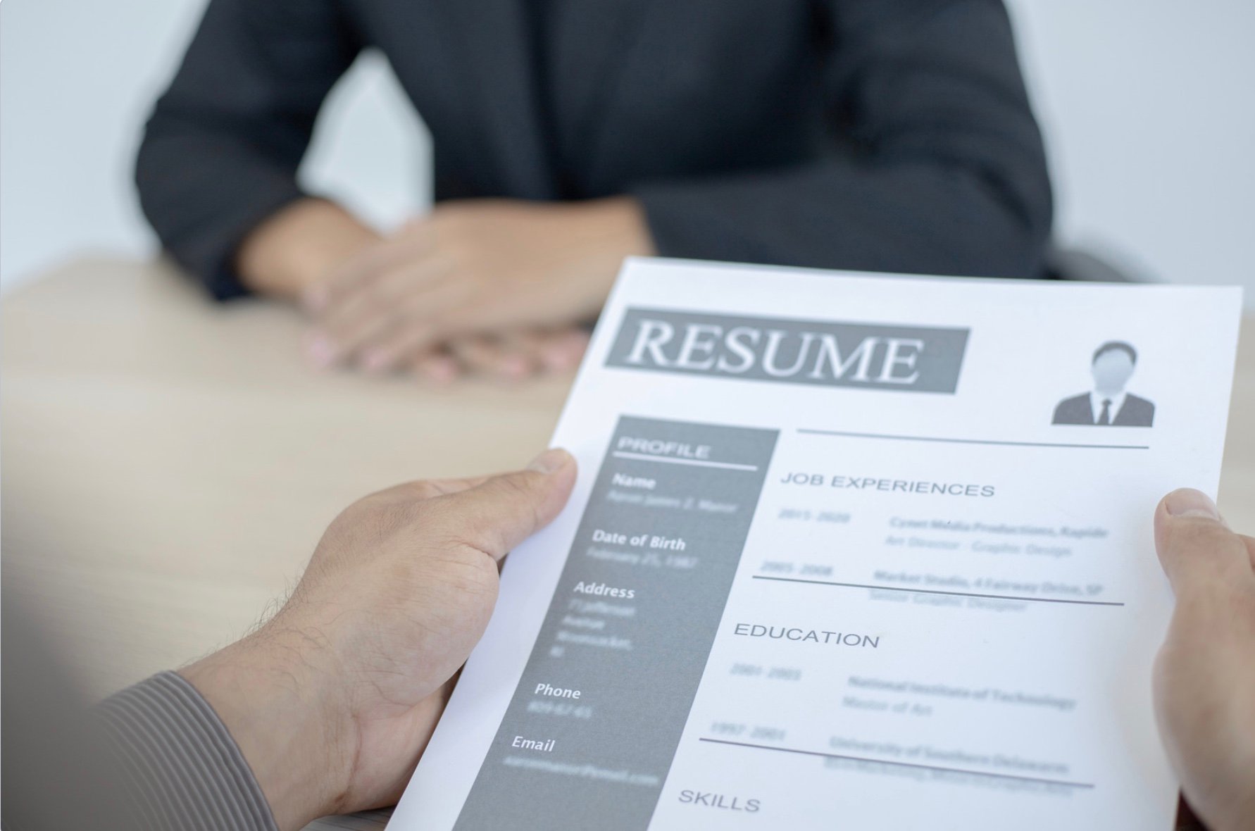 an interviewer looking at a candidates resume 