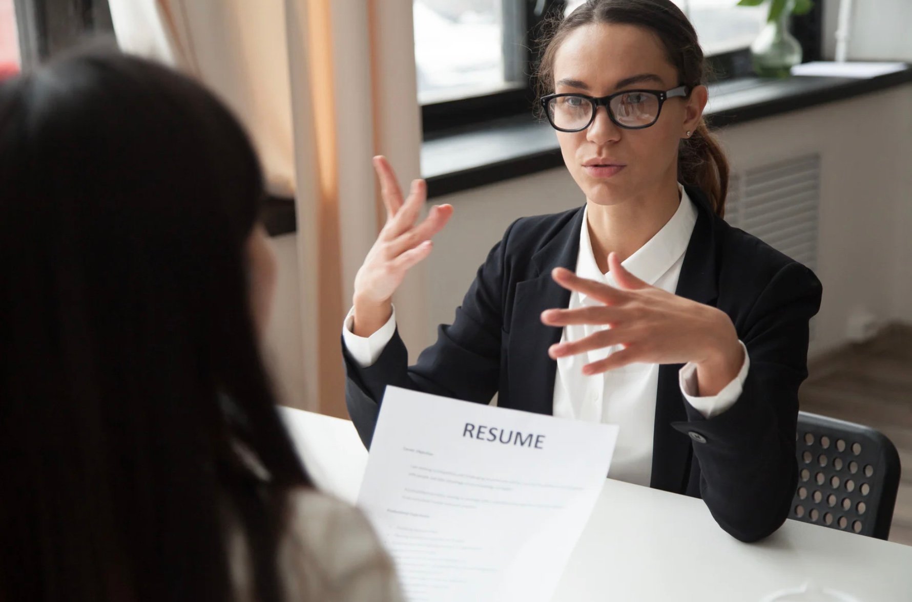 an interviewee talking and gesturing with her hands