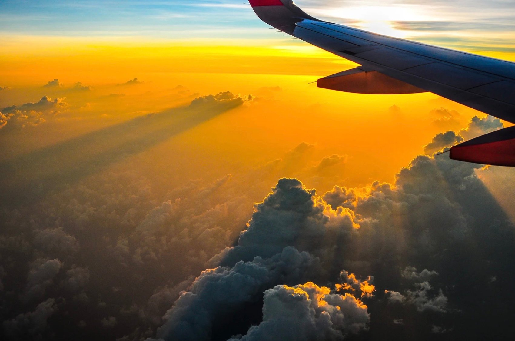 the outside view of an airplane flying in the sunset