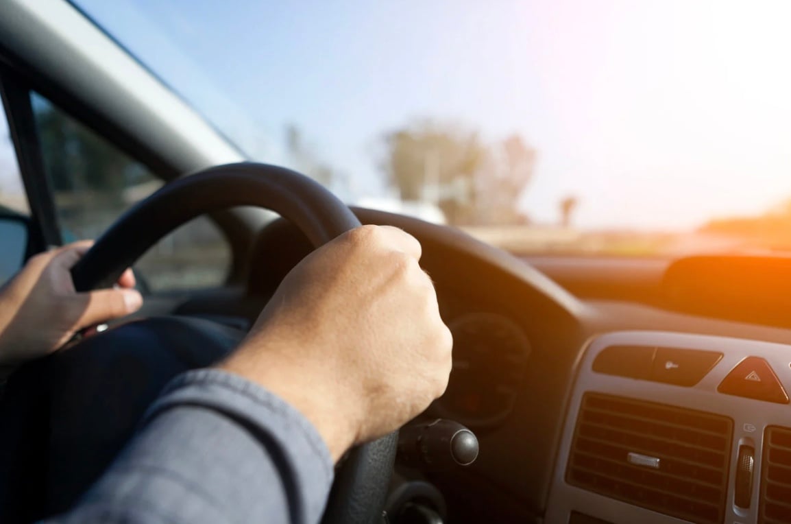 a drivers hands on the steering wheel