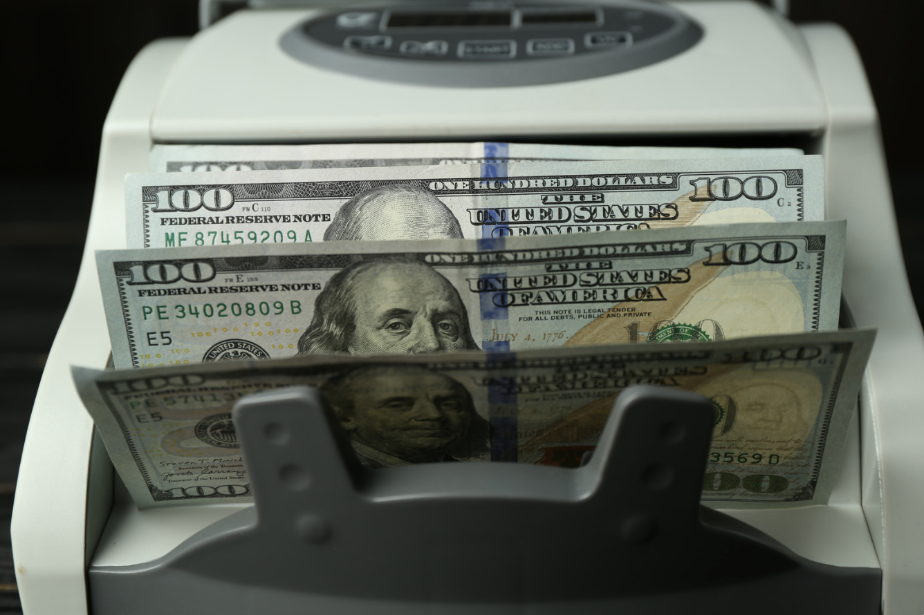 Dollar bills being counted in a money counter machine