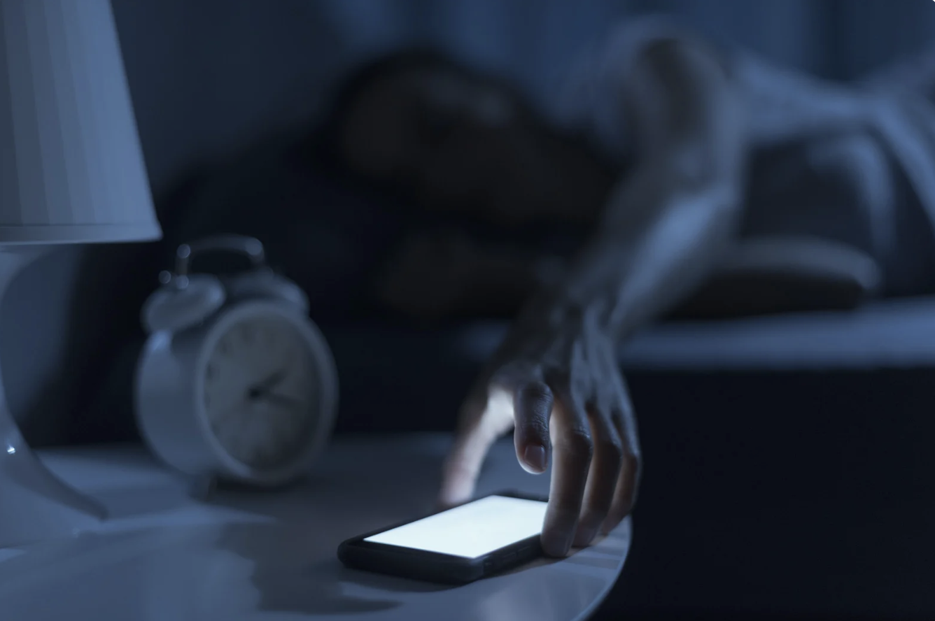 a woman picking up her cellphone in the middle of the night 