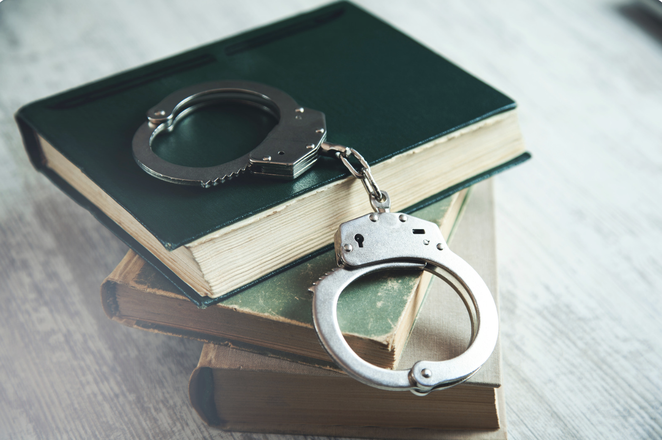 Hand cuffs laying over law books