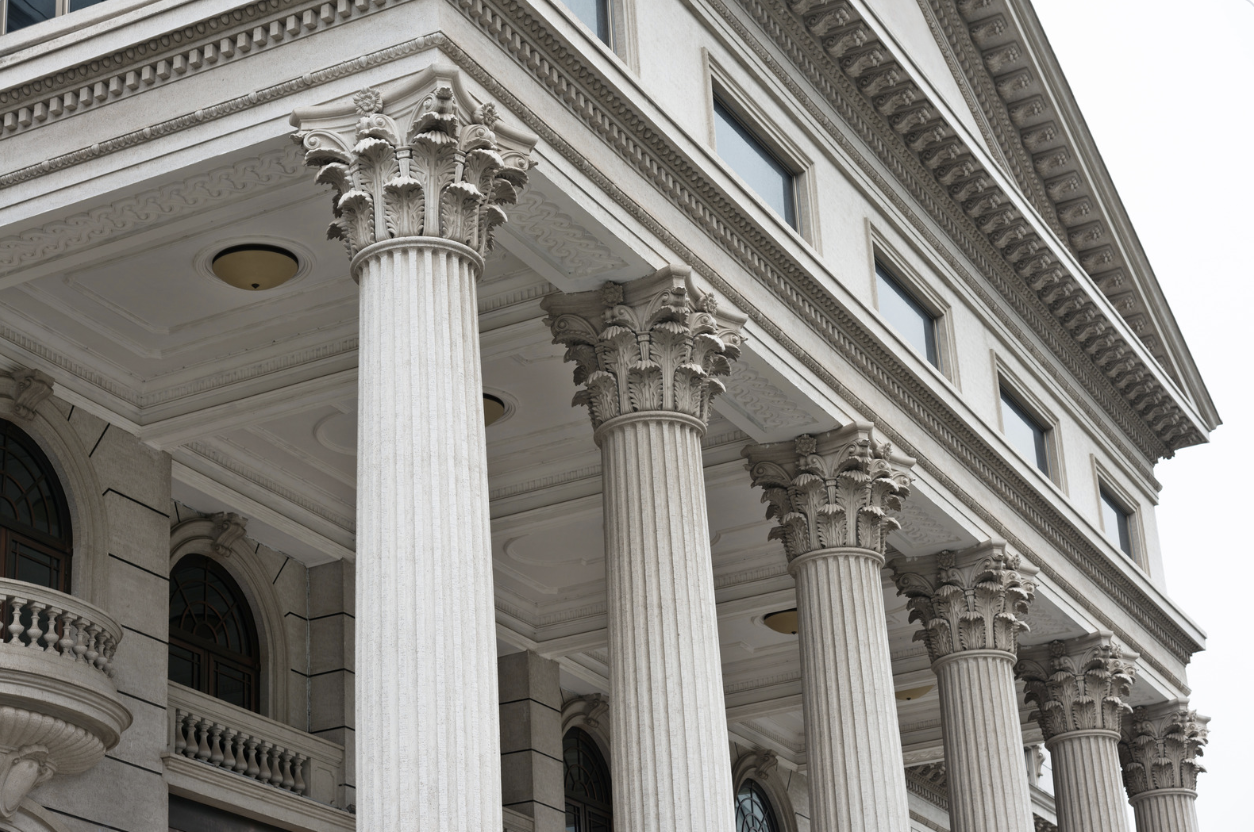 an angled exterior view of a court house with greco pillars at the entrance.