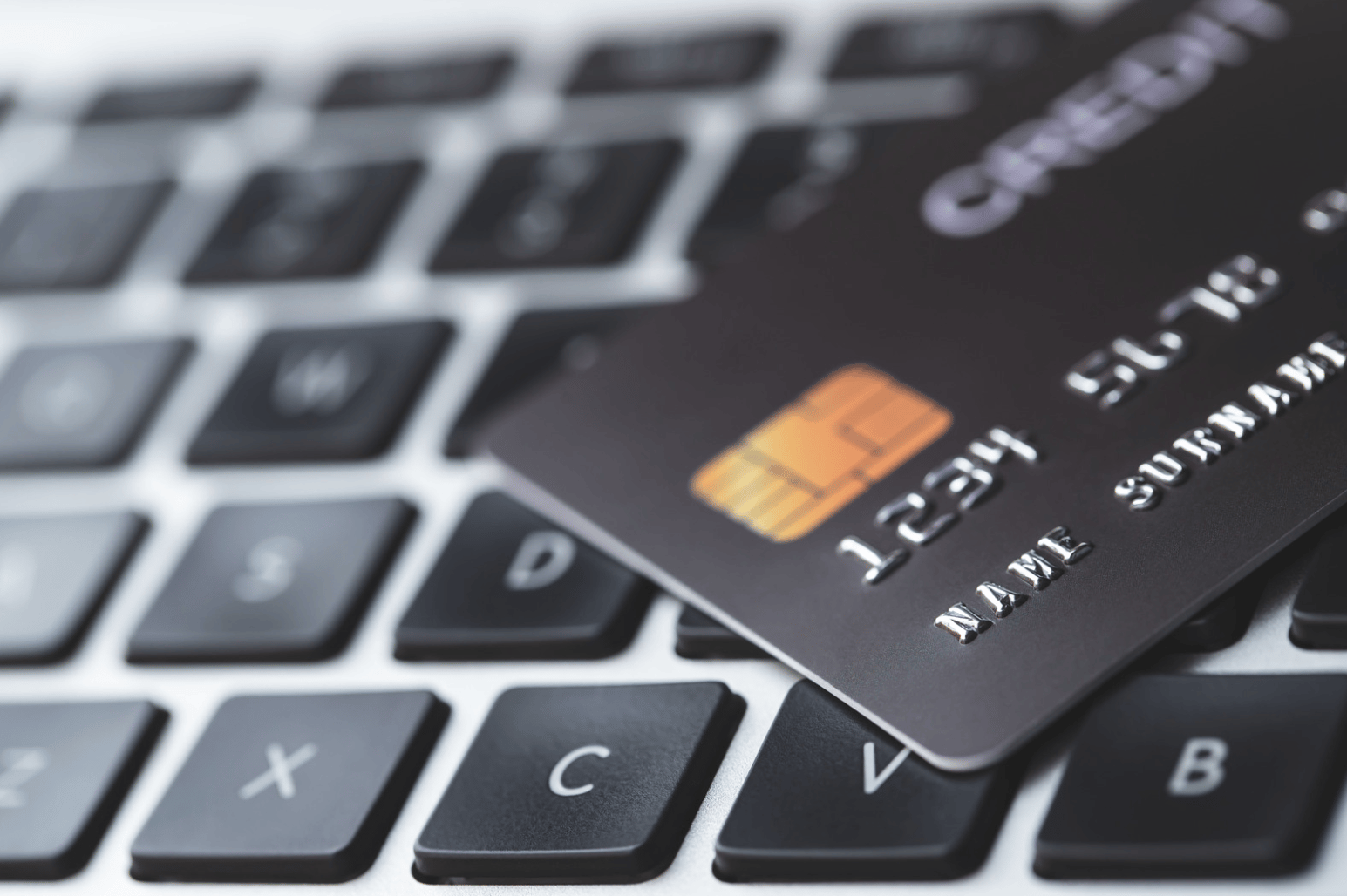 a credit card on top of the key board of a laptop